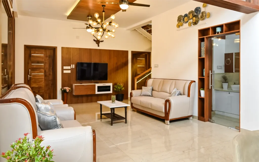 Living area with wooden doors and TV panel – Avanti Residence Thrissur