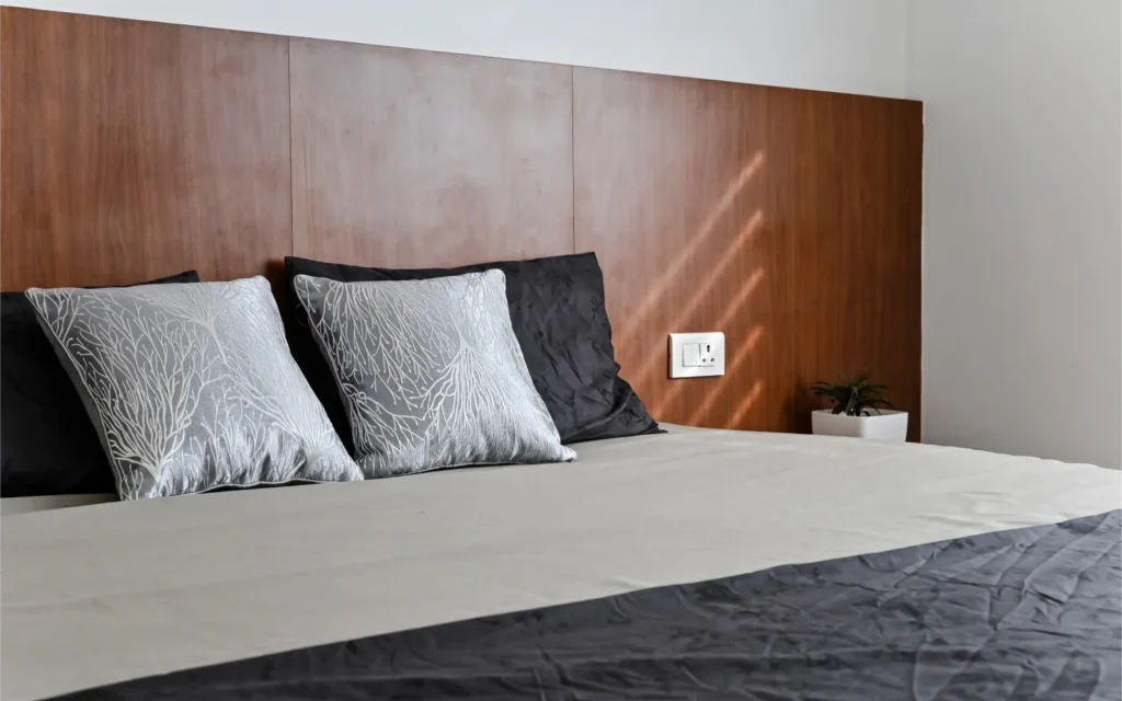 Modern bedroom interior with wooden headboard and wall décor – Avanti Residence, VB Infra