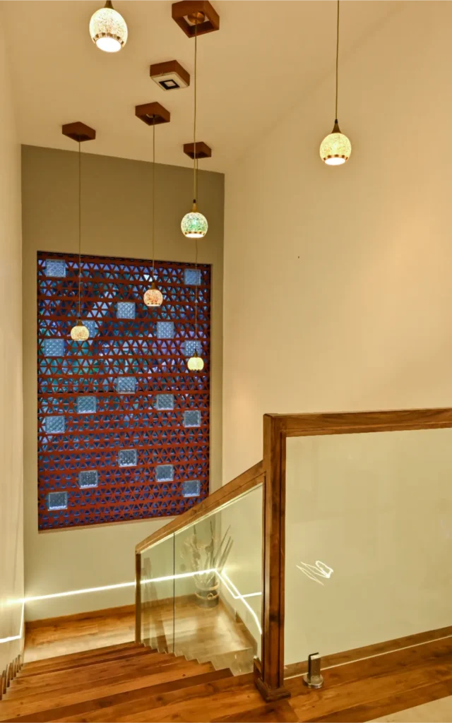 Wooden staircase with decorative lighting and jali wall feature – Avanti Residence, Thrissur
