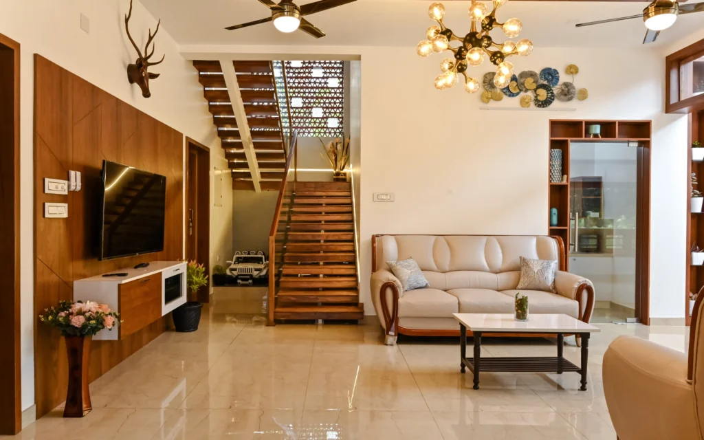 Living room with TV wall and wooden staircase – Avanti Residence Thrissur