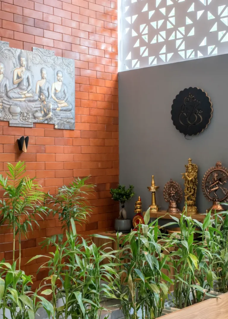 Prayer area with terracotta brick wall and brass idols – Castle Residence Thiroor