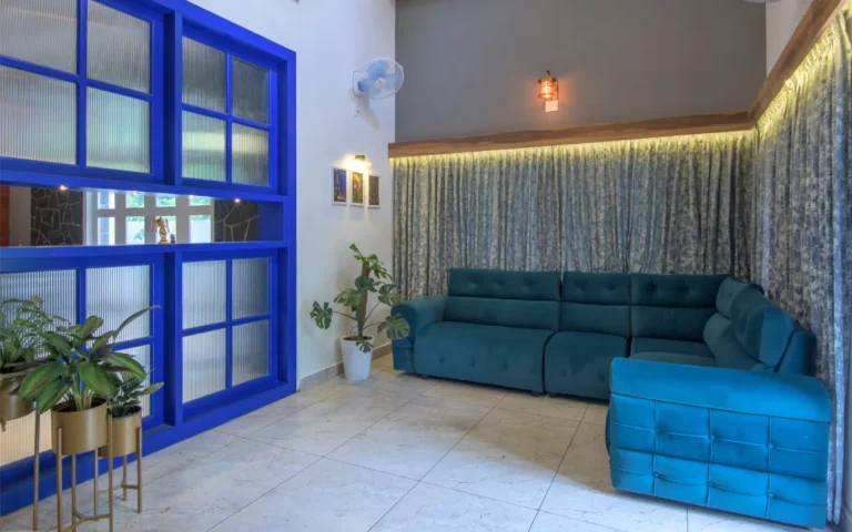 Living room with blue partition and teal sofa – Castle Residence Thiroor