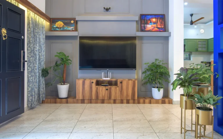 TV wall unit with grey paneling and indoor plants – Castle Residence Thiroor