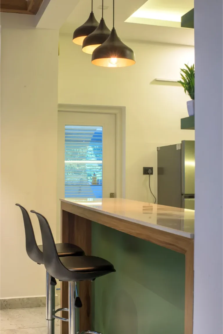 Kitchen breakfast counter with hanging lights and bar stools – Castle Residence Thiroor