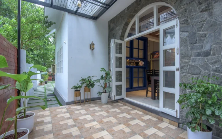 Front patio with stone wall and plants – Castle Residence Thiroor