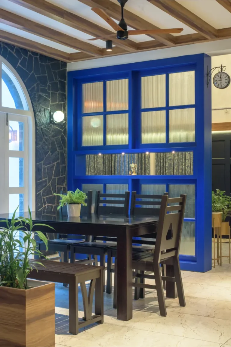 Black stone wall dining area with blue frame partition – Castle Residence Thiroor