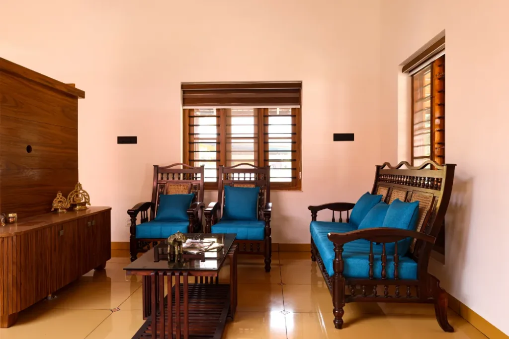 Traditional living room with blue cushioned wooden furniture – Courtyard House Wadakkanchery