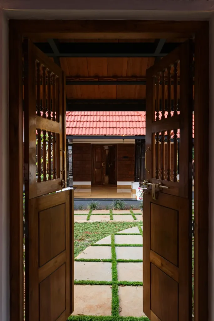 Wooden entrance doors opening to courtyard – Courtyard House Wadakkanchery
