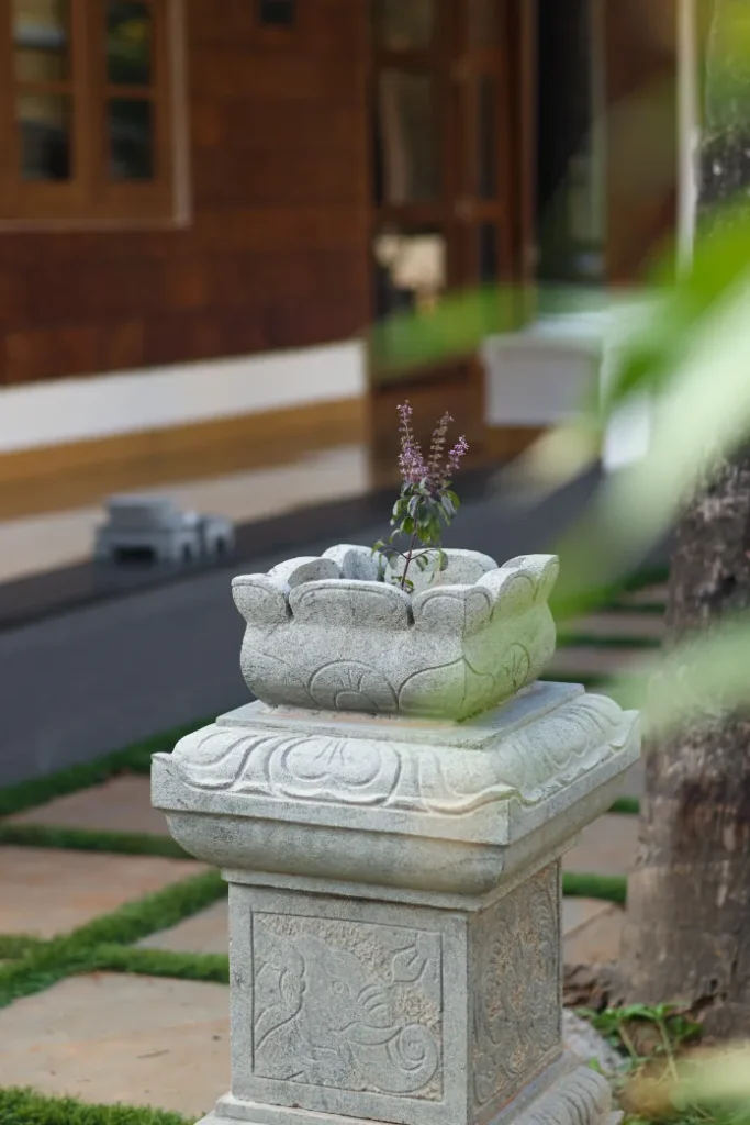 Tulsi plant placed on stone pedestal in front yard – Courtyard House Wadakkanchery
