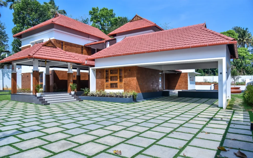 Front elevation with red tiled sloped roof and large courtyard – Trikkur Residence Thrissur