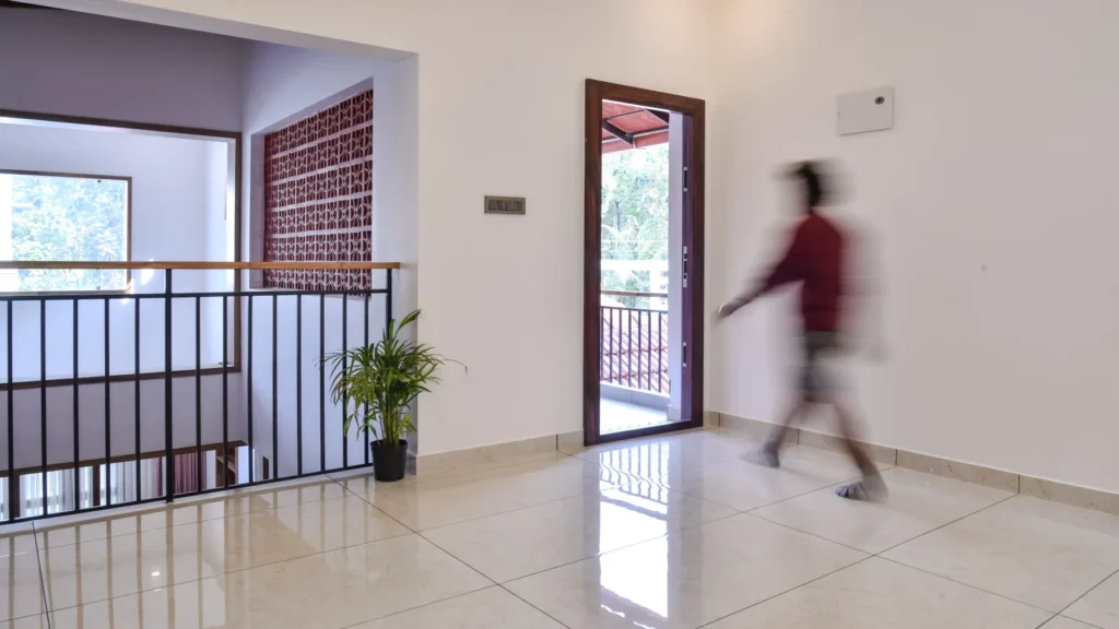 Upper floor corridor with railing and jali wall – Trikkur Residence Thrissur