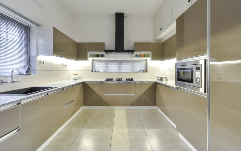 Modular kitchen with beige glossy cabinets and chimney – Trikkur Residence Thrissur