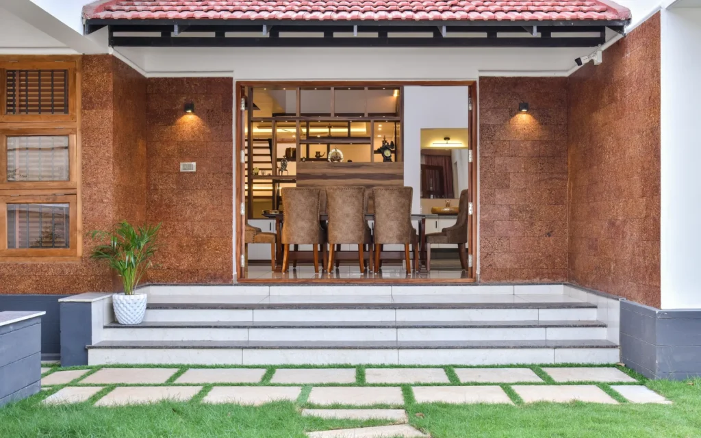Dining area opening to courtyard with tiled roof – Trikkur Residence Thrissur