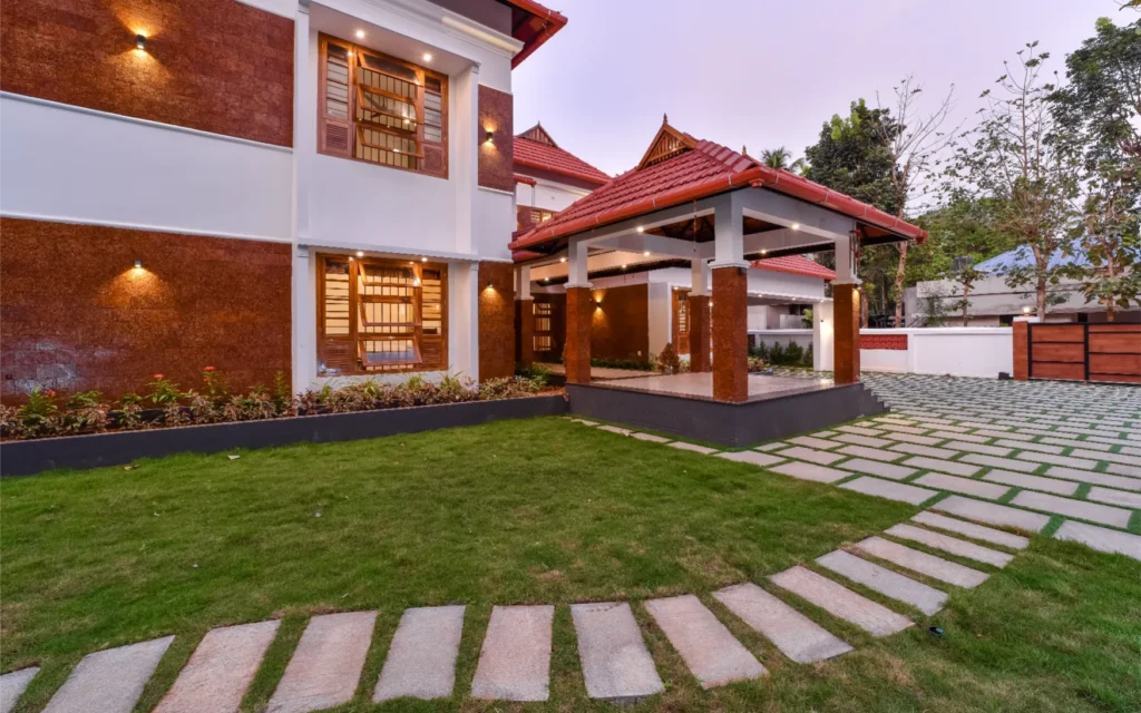 Evening exterior view of Kerala-style home with tiled roof – Trikkur Residence Thrissur
