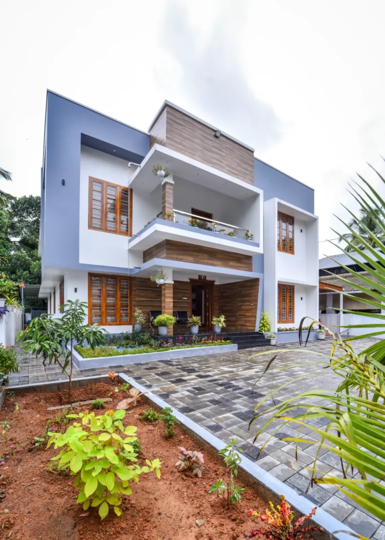 Daytime exterior view with blue and wooden accents – Varghese Residence Wadakkanchery
