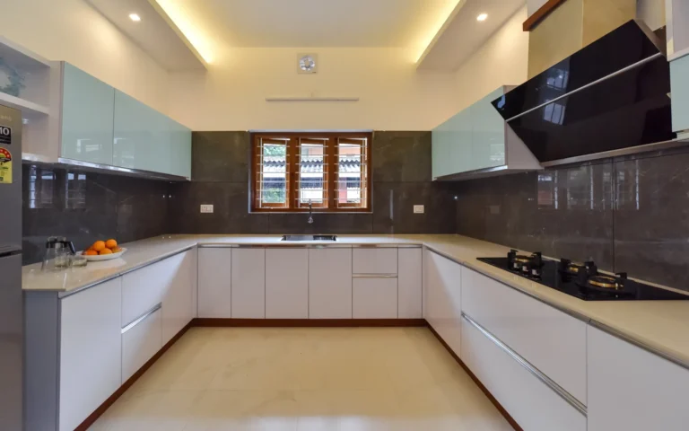 Modular kitchen with U-shaped countertop and soft lighting – Varghese Residence Wadakkanchery