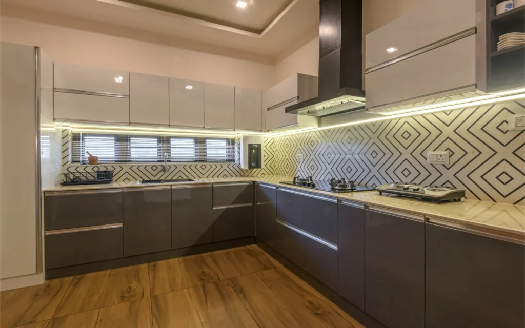 Modular kitchen with brown cabinets and LED under-cabinet lighting – Vasudevam Residence Chalakudy