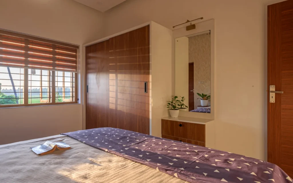 Bedroom with bed and window blinds in morning light – Vasudevam Residence Chalakudy