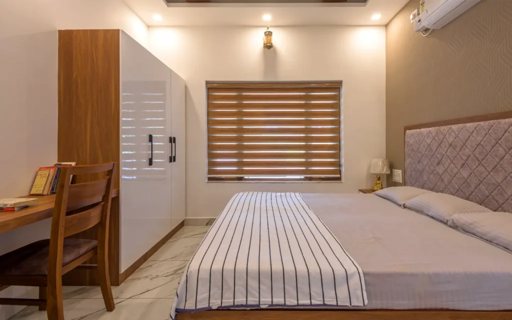 Bedroom with upholstered headboard and wooden study desk – Vasudevam Residence Chalakudy