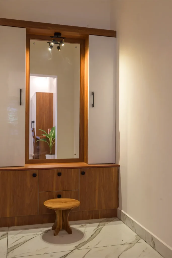 Dressing unit with wooden mirror frame and white cabinets – Vasudevam Residence Chalakudy